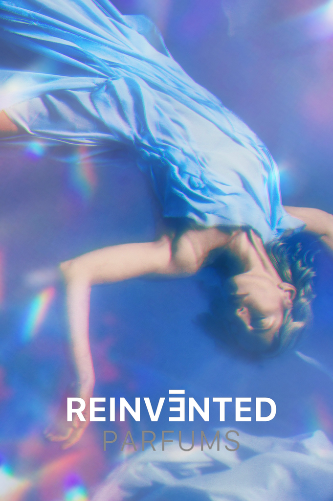 lucid dream perfume bottle by Reinvented Parfums, niche fragrance saffron rose oud, luxury unisex perfume flatlay, dreamy surreal perfume imagery