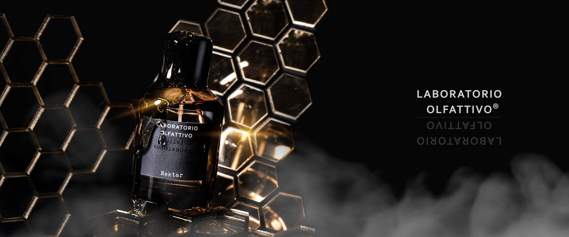 A bottle of Laboratorio Olfattivo perfume labeled Nektar stands in front of golden honeycomb-shaped structures with mist swirling around, set against a dark background. The brand name appears on the right side.